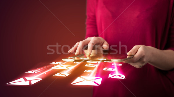 Stock photo: Hand holding tablet and sending email icons