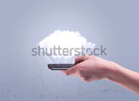 Hand holding phone with empty cloud Stock photo © ra2studio