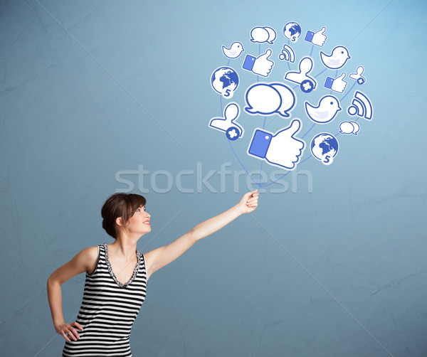 Pretty woman holding social icon balloon Stock photo © ra2studio