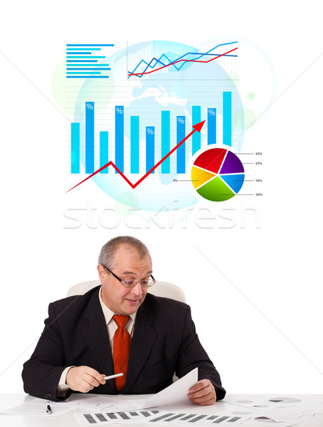 Biznesmen posiedzenia biurko statystyka odizolowany biały Zdjęcia stock © ra2studio