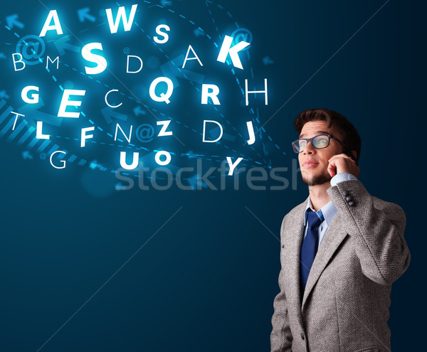 Stock photo: Young boy making phone call with shiny characters