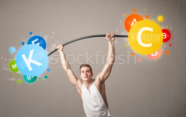 muscular man lifting colorful vitamin weights Stock photo © ra2studio
