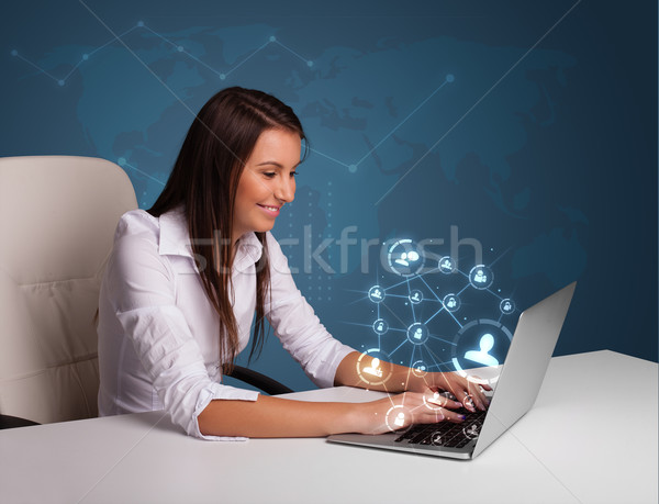 Young Lady Sitting At Desk And Typing On Laptop With Social Netw