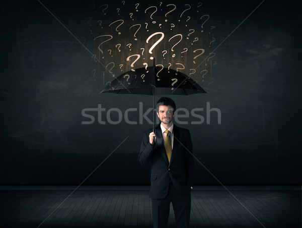 Businessman with umbrella and a lot of drawn question marks Stock photo © ra2studio