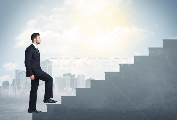 Businessman climbing up a concrete staircase concept Stock photo © ra2studio