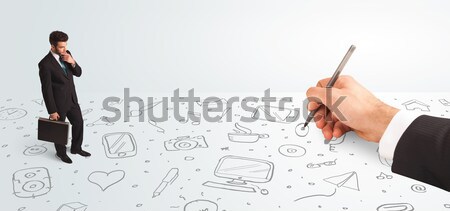 Little businessman looking at hand drawn icons and symbols Stock photo © ra2studio