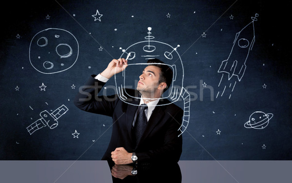 Sales person drawing helmet and space rocket Stock photo © ra2studio