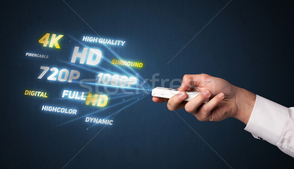 Hand with remote control and multimedia properties Stock photo © ra2studio