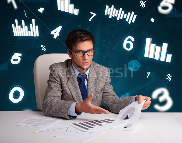 Businessman sitting at desk with diagrams and statistics Stock photo © ra2studio