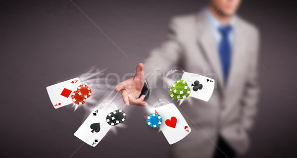Stock photo: Young man playing with poker cards and chips