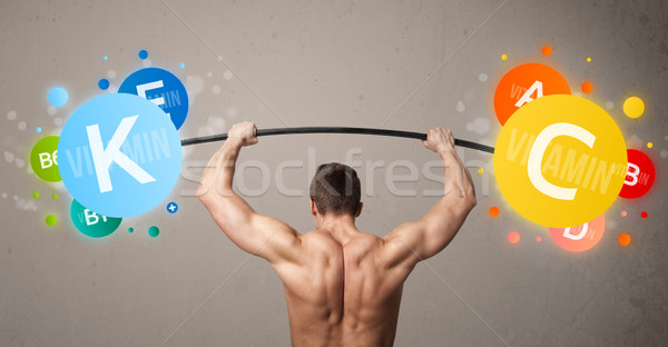 Muskuläre Mann Heben farbenreich Vitamin Gewichte Stock foto © ra2studio
