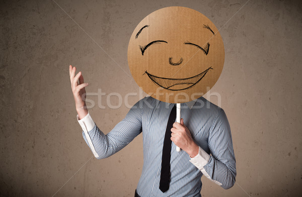 Businessman holding a smiley face board Stock photo © ra2studio