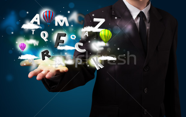 Young businessman presenting magical clouds with letters and bal Stock photo © ra2studio