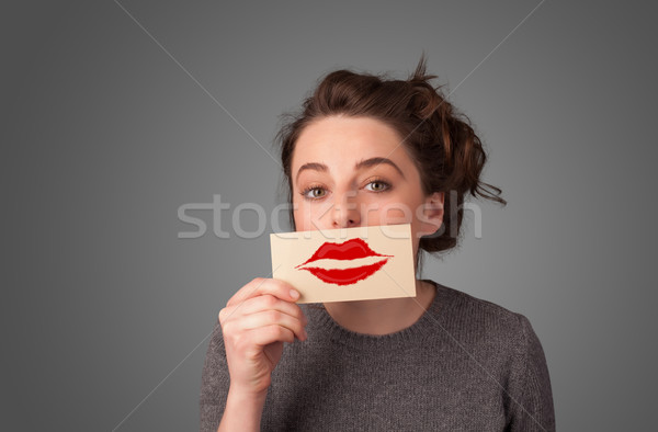 Stock photo: Happy pretty woman holding card with kiss lipstick mark