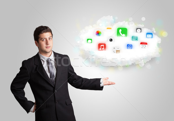 Young man presenting cloud with colorful app icons and symbols Stock photo © ra2studio