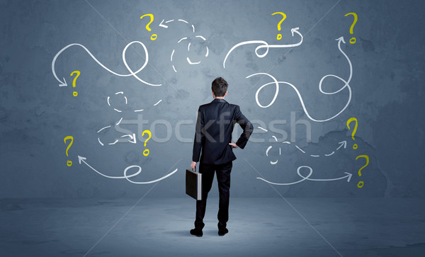 Unsure businessman with question marks Stock photo © ra2studio