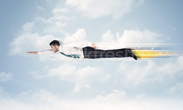 Stock photo: Happy business man flying fast on the sky between clouds