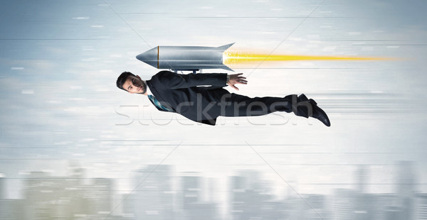 Superhero business man flying with jet pack rocket above the cit Stock photo © ra2studio