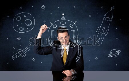 Sales person drawing helmet and space rocket Stock photo © ra2studio