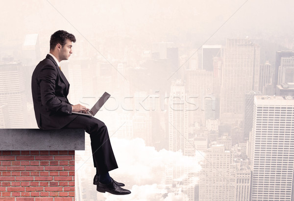 Office worker sitting on rooftop in city Stock photo © ra2studio