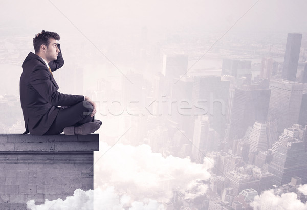 Sales person sitting on building edge in city Stock photo © ra2studio