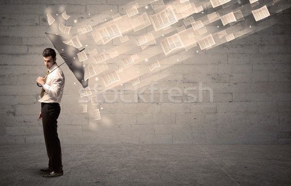 Business man protecting with umbrella against wind of papers Stock photo © ra2studio