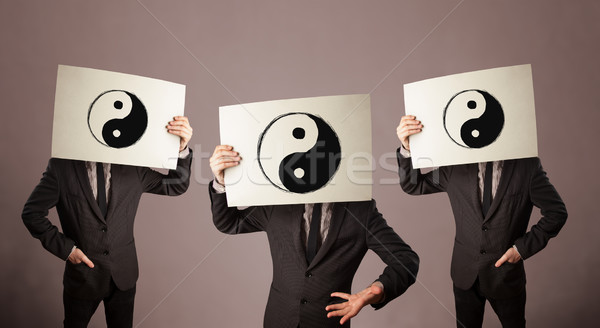 Handsome people in formal gesturing with yin yang sign on cardbo Stock photo © ra2studio