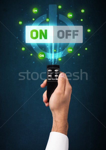 Stock photo: Hand with remote control and on-off signals