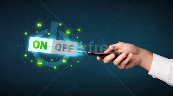 Stock photo: Hand with remote control and on-off signals