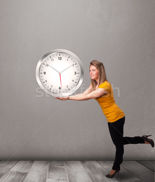 Attractive lady holding a huge clock Stock photo © ra2studio