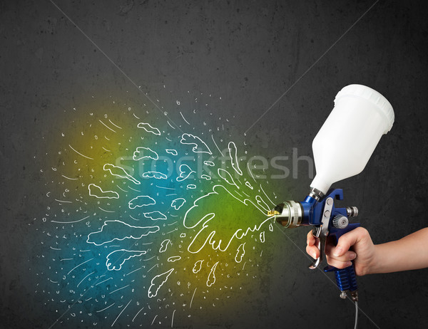 Worker with airbrush gun paints colorful lines and splashes Stock photo © ra2studio