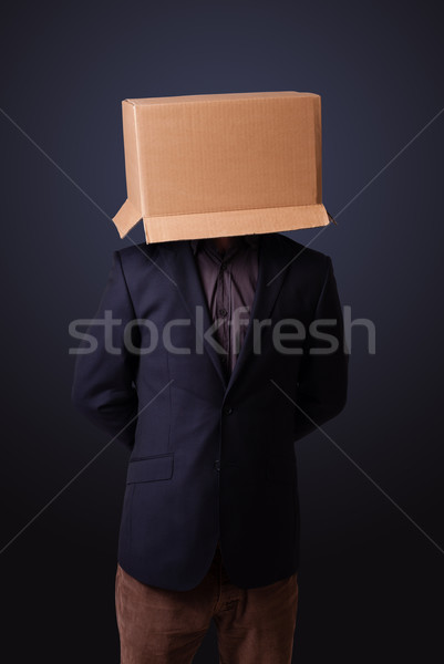 Young man gesturing with a cardboard box on his head Stock photo © ra2studio