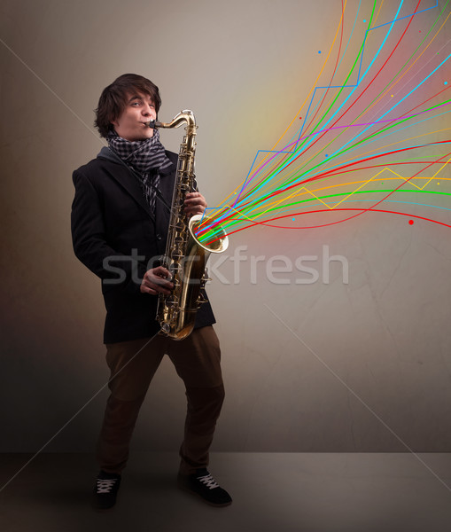 Attractive musician playing on saxophone while colorful abstract Stock photo © ra2studio