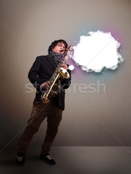 Young man playing on saxophone with copy space in white cloud Stock photo © ra2studio