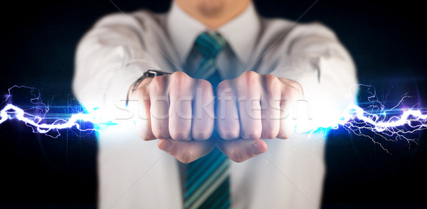 Stock fotó: üzletember · tart · elektromosság · fény · csavar · kezek