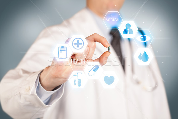 A doctor in white holding a pill Stock photo © ra2studio