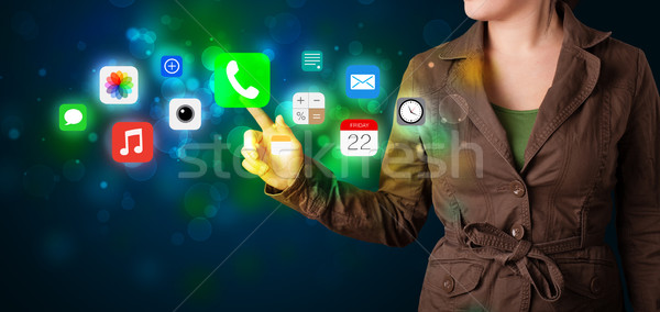 Young businesswoman pressing colorful mobile app icons with boke Stock photo © ra2studio