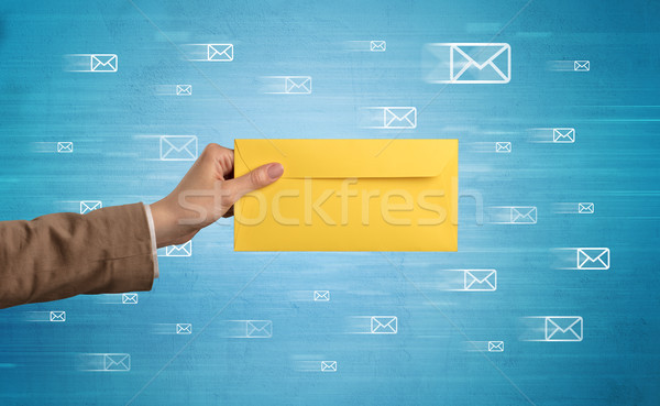 Hand holding envelope with message symbols around Stock photo © ra2studio