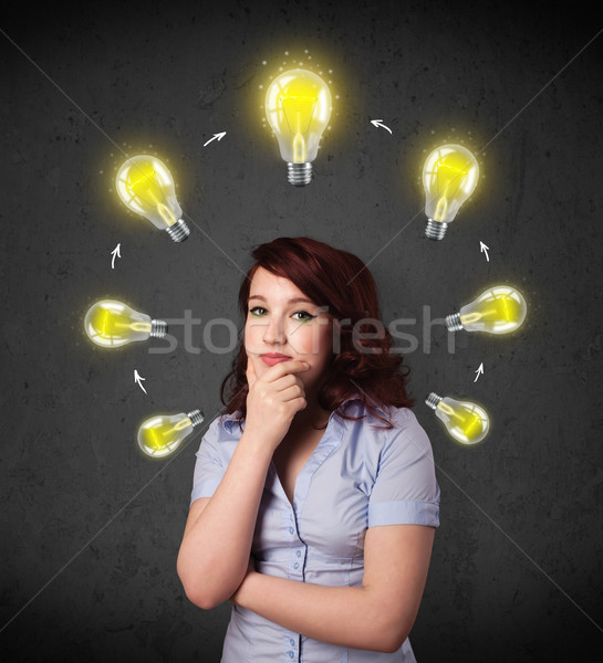 Young woman thinking with lightbulb circulation around her head Stock photo © ra2studio