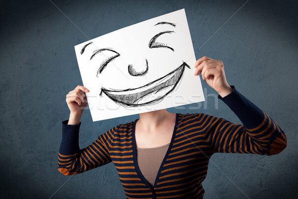 Woman with drawed smiley face on a paper in front of her head Stock photo © ra2studio