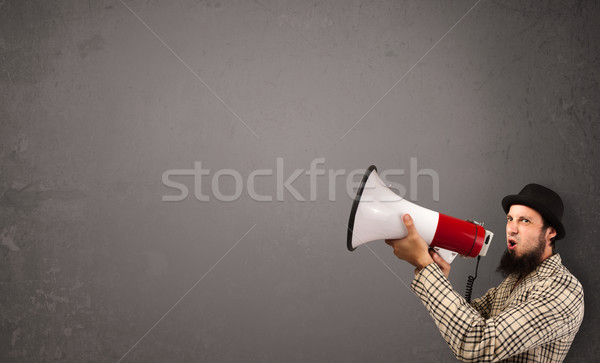 Guy shouting into megaphone on copy space background Stock photo © ra2studio