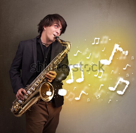 Foto stock: Jóvenes · músico · jugando · saxófono · notas · musicales · atractivo