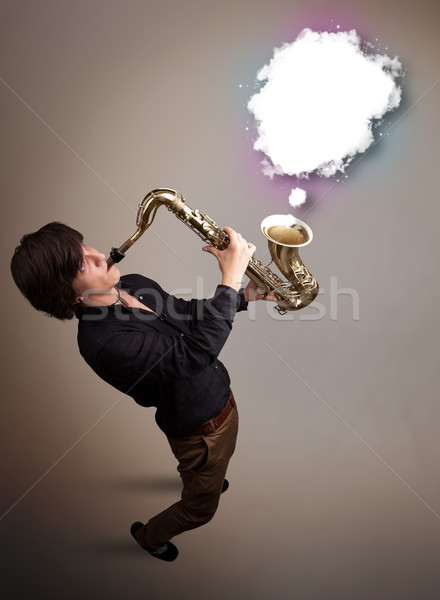 Young man playing on saxophone with copy space in white cloud Stock photo © ra2studio