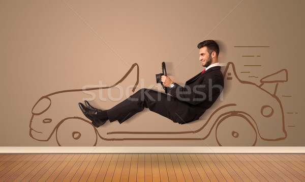 Happy man driving an hand drawn car on the wall Stock photo © ra2studio