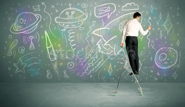 Young businessman drawing rocket Stock photo © ra2studio