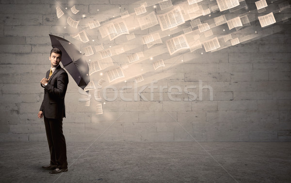 Business man protecting with umbrella against wind of papers Stock photo © ra2studio