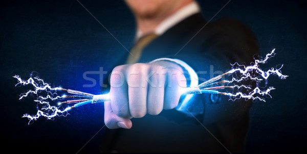Business person holding electrical powered wires Stock photo © ra2studio