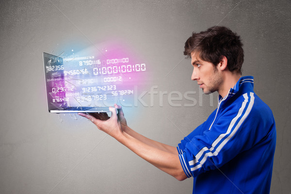 Casual man holding laptop with exploding data and numbers Stock photo © ra2studio