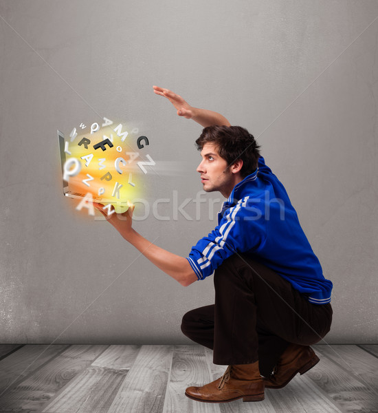 Attractive young man hoding notebook with colorful letters Stock photo © ra2studio