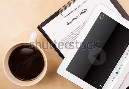 Workplace with tablet pc showing media player and a cup of coffee on a wooden work table closeup Stock photo © ra2studio